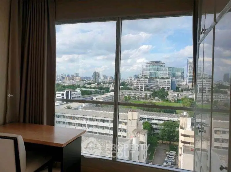 Stunning cityscape view from a modern apartment window with a cozy study desk.