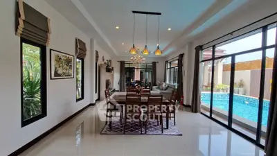 Luxurious open-plan living room with pool view, elegant dining area, and modern decor.