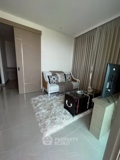 Modern living room with sleek design, featuring a cozy sofa, stylish rug, and flat-screen TV for ultimate comfort.