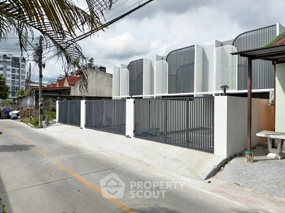 Modern townhouse exterior with sleek design and gated entrance in urban setting.