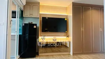 Modern living room with sleek cabinetry and large TV, featuring elegant lighting and wooden flooring.