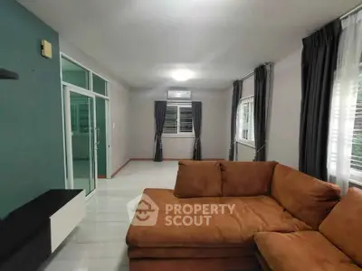 Spacious living room with modern sectional sofa and large windows for natural light.
