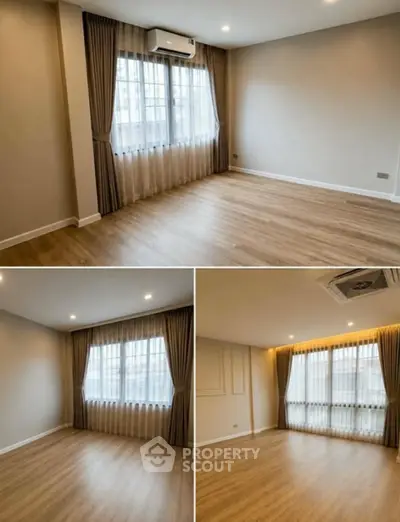 Spacious empty room with wooden flooring and large windows, perfect for customization.