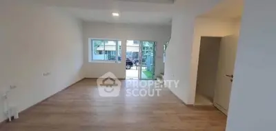 Spacious empty room with large windows and wooden flooring, ideal for customization.
