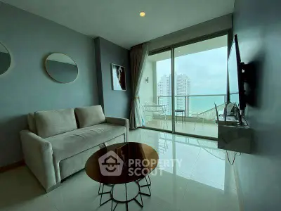 Modern living room with ocean view and balcony access in a high-rise apartment.