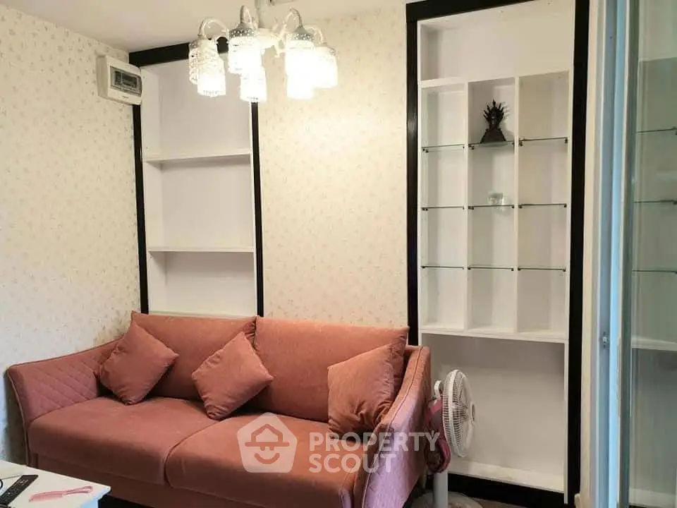 Cozy living room with stylish pink sofa and elegant shelving, perfect for modern living.