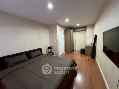 Modern bedroom with sleek design and wooden flooring, featuring a comfortable bed and stylish furniture.