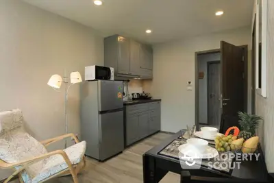 Modern kitchen with dining area and cozy seating, featuring sleek appliances and stylish decor.