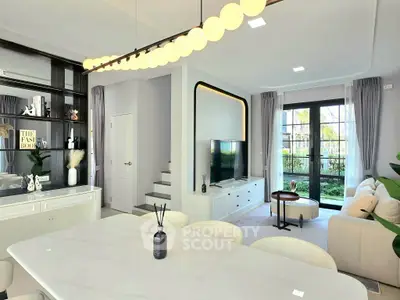 Modern living room with elegant decor and garden view, featuring sleek furniture and stylish lighting.