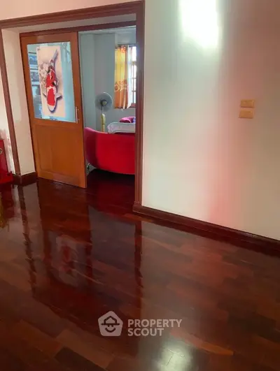 Spacious interior with polished wooden floors and cozy living area, perfect for modern living.