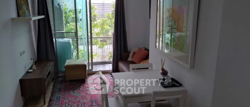 Charming living room with balcony view, modern furniture, and vibrant decor.