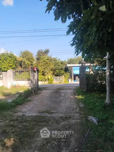 Charming rural property with gated entrance and lush greenery, perfect for serene living.