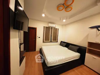 Modern bedroom with sleek design, featuring a large bed, wall-mounted TV, and stylish lighting.