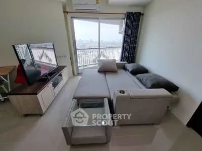 Modern living room with city view, featuring sleek furniture and large windows for natural light.