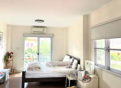 Bright bedroom with large windows and cozy decor in modern home