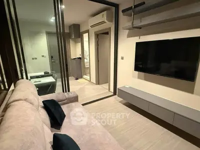 Modern living room with sleek design, featuring a wall-mounted TV and cozy seating area.