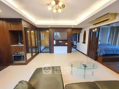 Spacious open-plan living room with modern kitchen and cozy bedroom view.