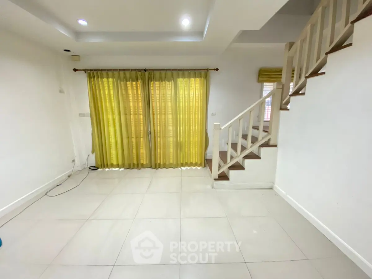 Spacious interior with staircase and large windows, perfect for modern living.