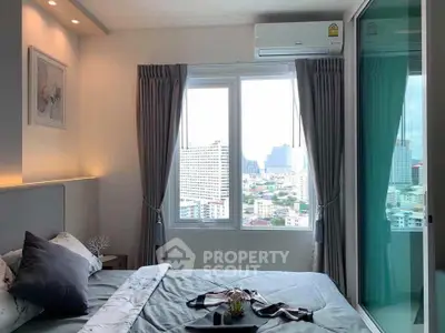 Modern bedroom with city view, featuring stylish decor and large windows for natural light.