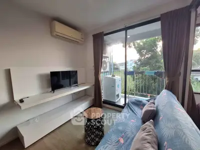 Cozy living room with balcony view, featuring air conditioning and modern decor.
