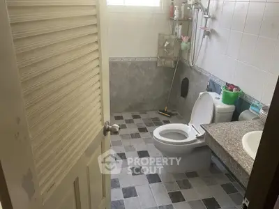 Spacious bathroom with modern fixtures and tiled flooring, featuring a shower and toilet.