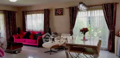 Elegant living room with vibrant red sofa, chic decor, and ample natural light from large windows.