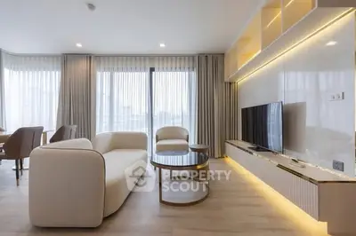 Modern living room with elegant furniture and large windows offering natural light.