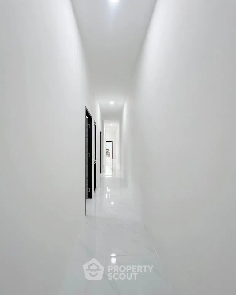 Sleek modern corridor with glossy white marble flooring and minimalist design.
