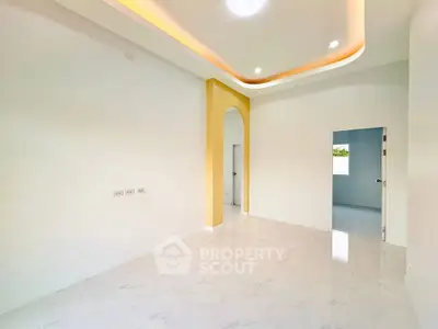 Spacious modern interior with elegant ceiling design and bright natural lighting.