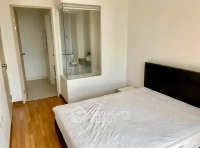 Modern bedroom with glass partition and wooden flooring