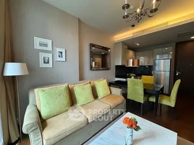 Stylish modern living room with open kitchen, elegant decor, and cozy seating area.