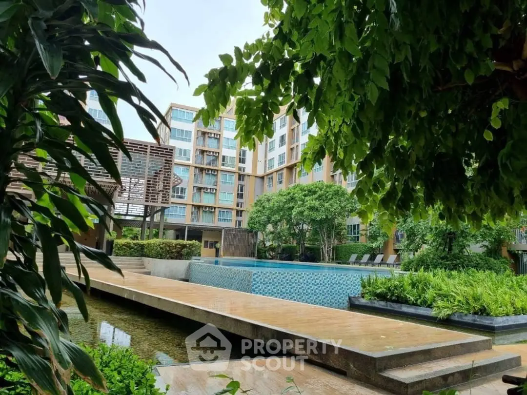 Luxurious apartment complex with serene pool and lush greenery