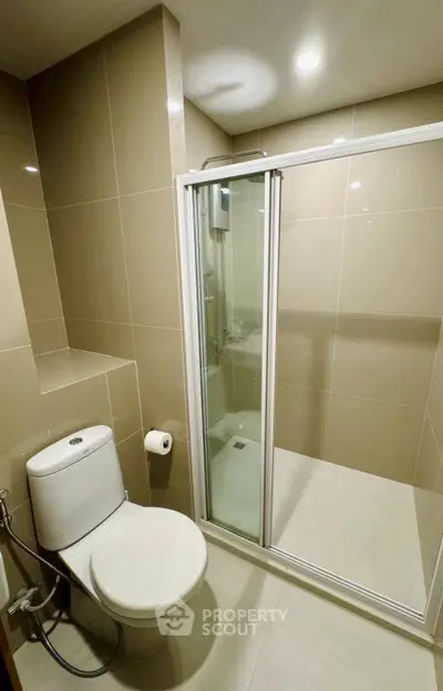 Modern bathroom with sleek shower and toilet in contemporary design.