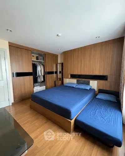 Spacious bedroom with modern wooden furniture and ample closet space