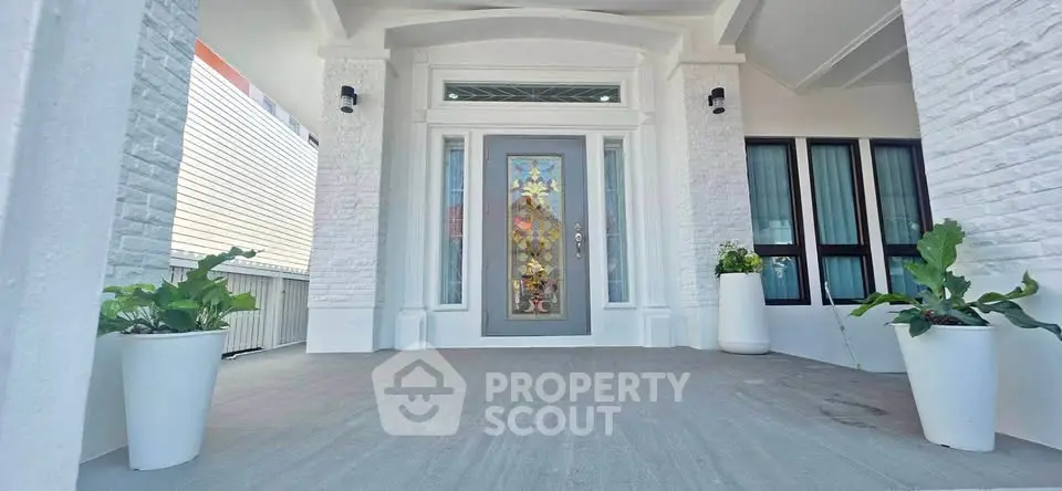 Elegant entrance with decorative glass door and modern white facade