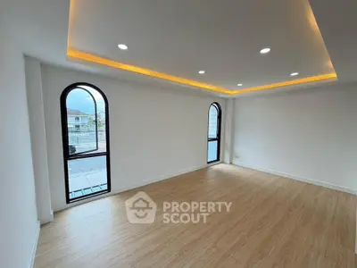 Spacious modern living room with elegant lighting and large windows offering scenic views.