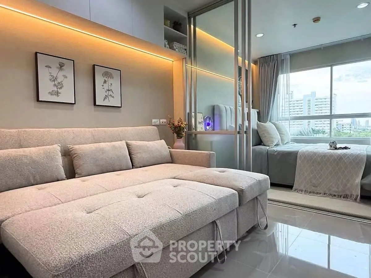 Modern studio apartment with cozy living area and bedroom, featuring elegant decor and city view.