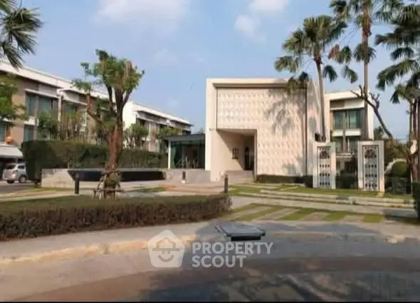 Modern residential building with lush landscaping and palm trees