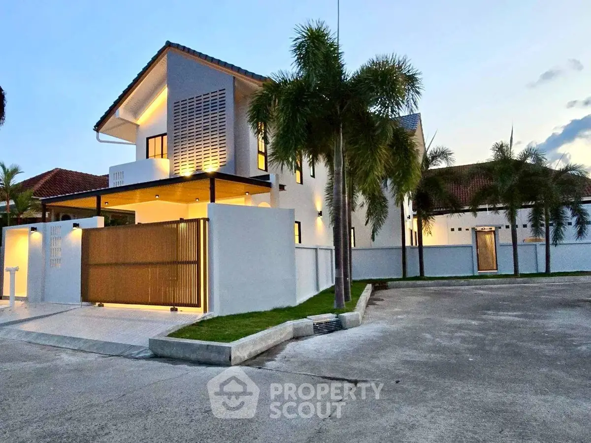 Stunning modern villa with elegant lighting and spacious driveway, perfect for luxurious living.