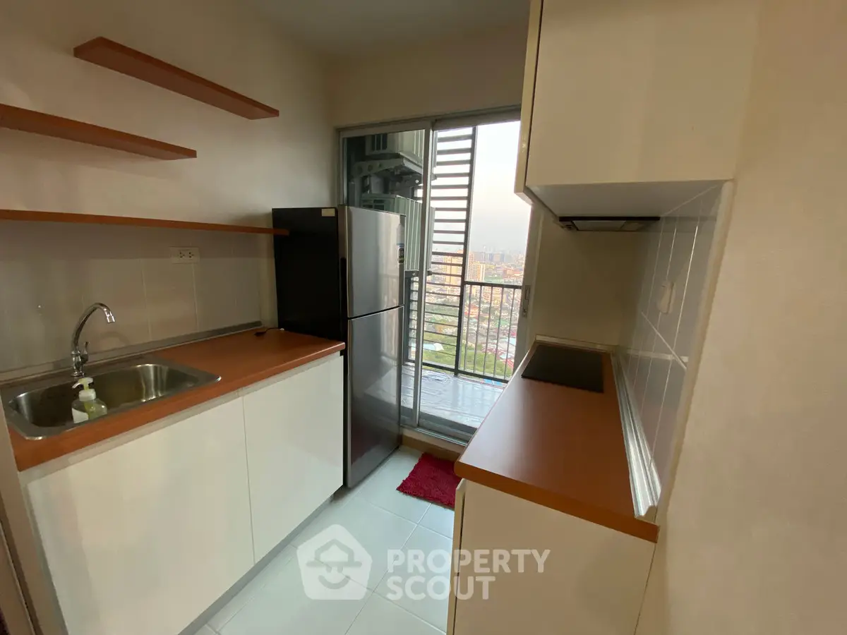 Modern kitchen with sleek cabinets and city view from balcony
