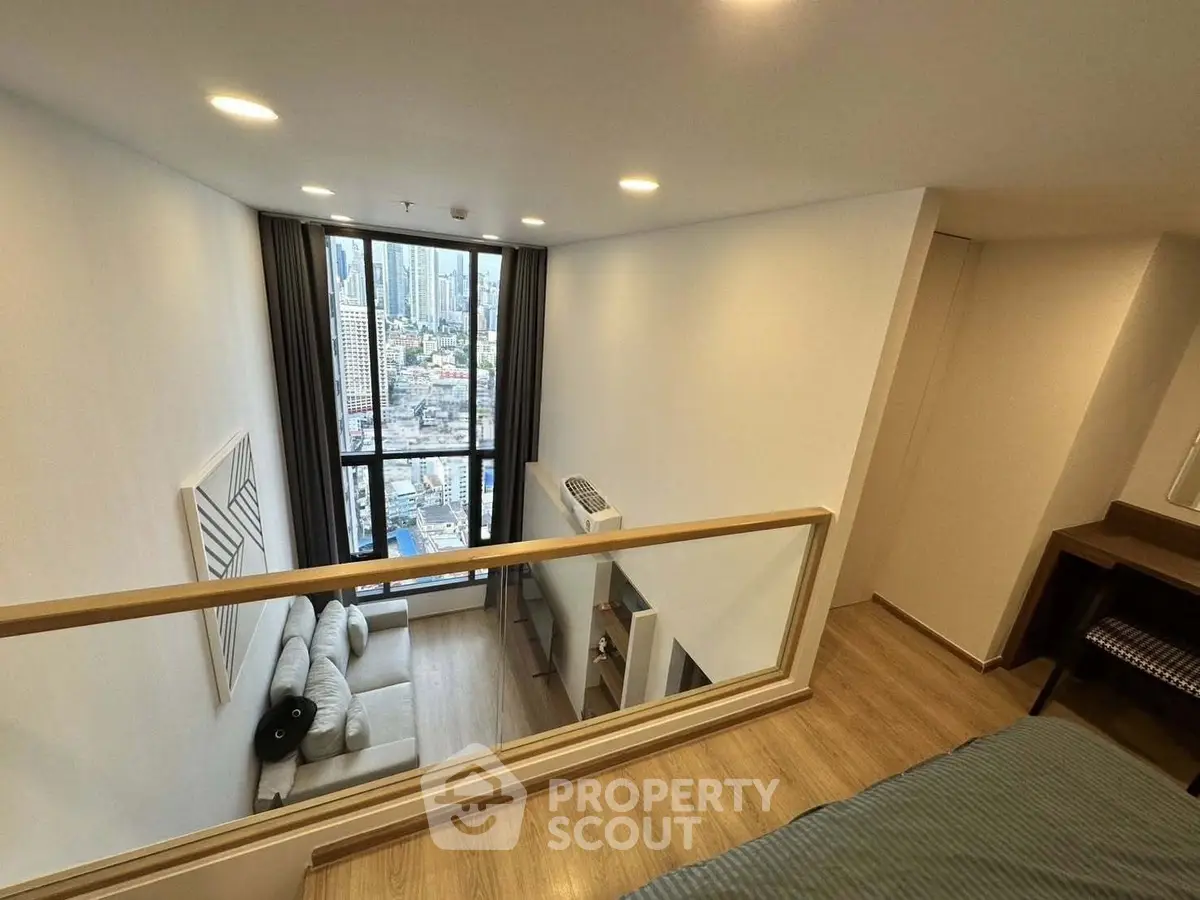 Modern loft apartment with high ceiling and city view, featuring cozy living area and stylish decor.