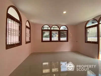 Spacious living room with arched windows and glossy tiled floor