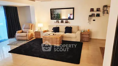 Spacious living room with modern decor, cozy seating, and elegant lighting