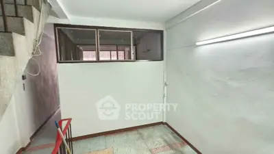 Spacious interior with staircase and large window, ideal for renovation.