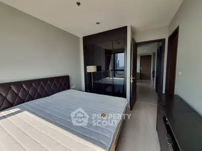 Modern bedroom with sleek design and city view, featuring a comfortable bed and stylish furniture.
