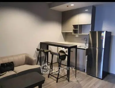 Modern compact kitchen with sleek appliances and cozy living area in urban apartment.