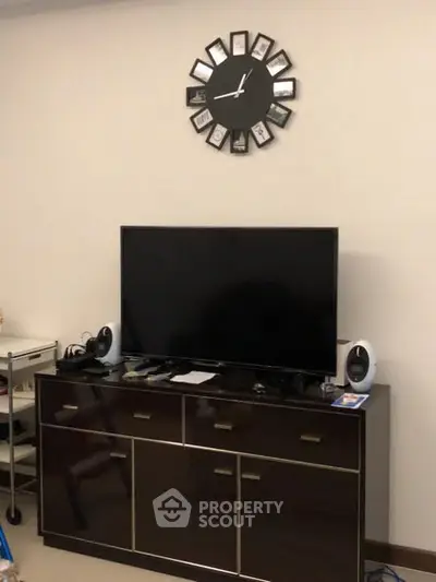 Modern living room with sleek TV stand and wall clock, perfect for contemporary home entertainment.