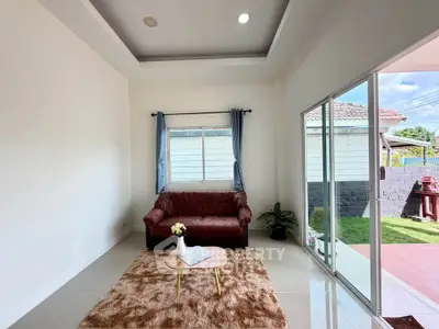 Bright living room with cozy sofa, plush rug, and sliding glass doors leading to a sunny garden.