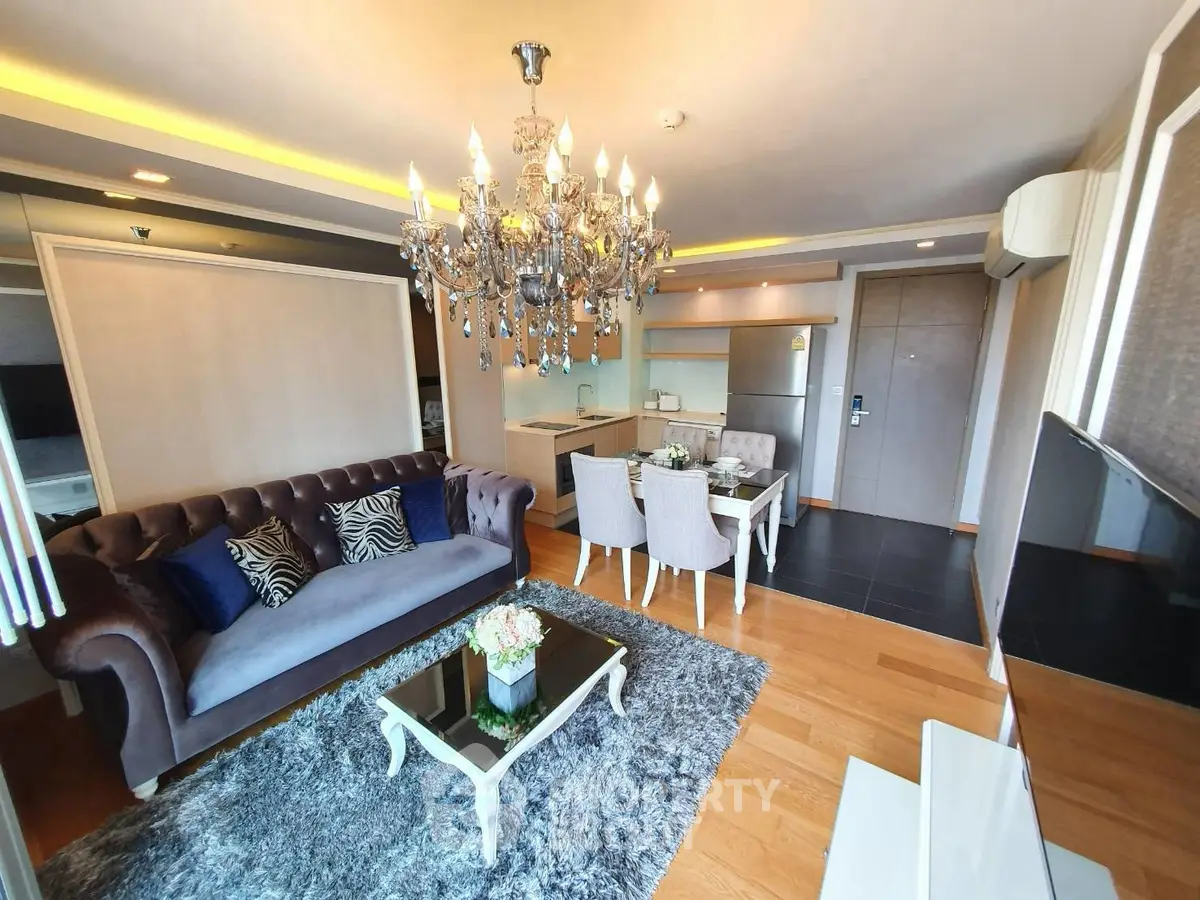 Luxurious living room with elegant chandelier and modern decor in upscale apartment.