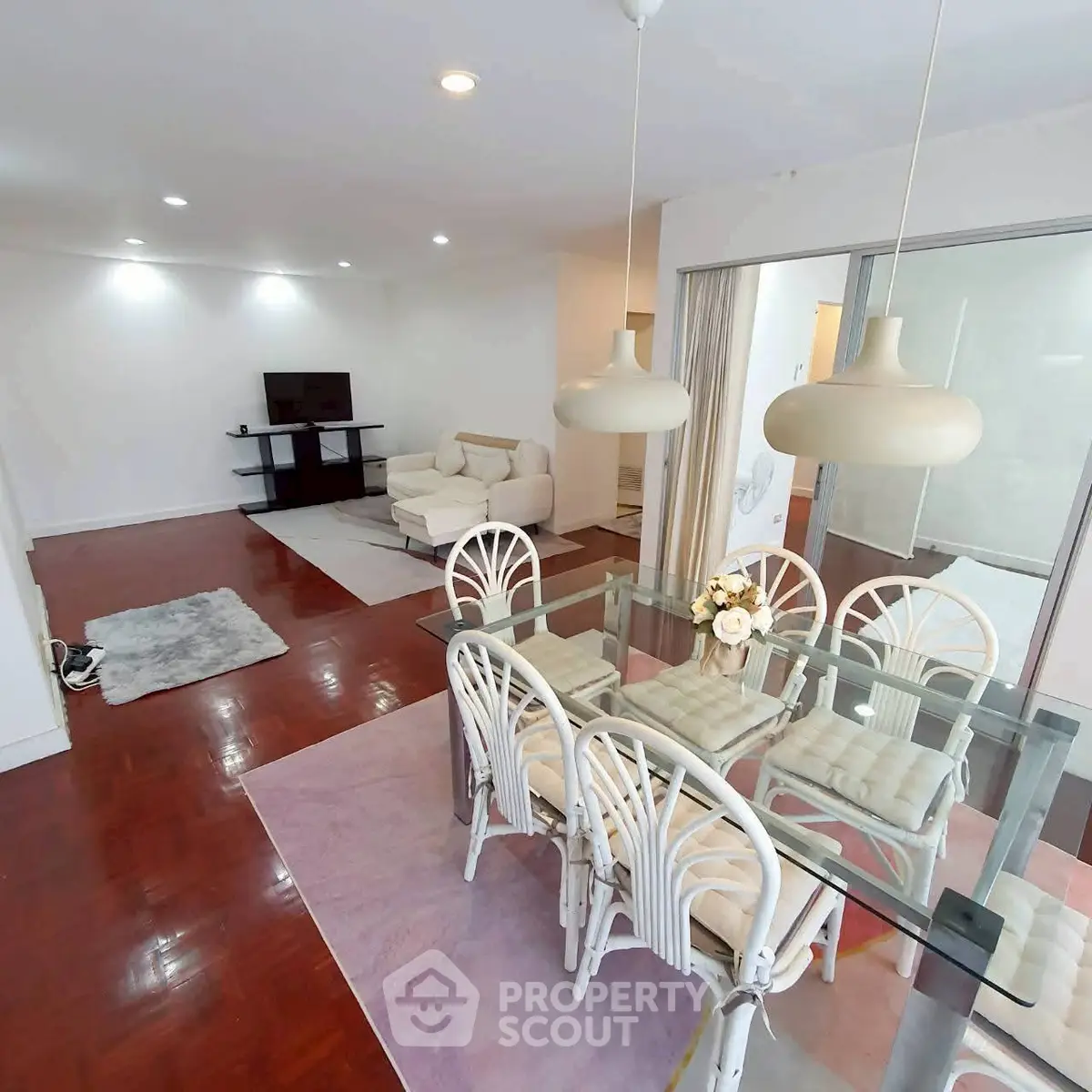 Spacious open-plan living and dining area with modern furnishings and elegant lighting.